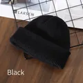 Classic black ribbed knit beanie for winter warmth on a stylish wooden surface - Black
