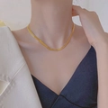 Dettaglio di una collana in acciaio al titanio dorato a maglia intrecciata sul collo - Collana / Oro