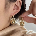 Detail of gold bow earrings with crystal-encrusted spheres on model ear - Rhinestone Bowknot Gold Ball