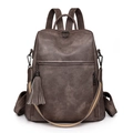 Macro detail of dark brown vintage backpack with fringe and striped shoulder strap - Gray