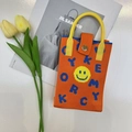 Detailed knit texture of orange mini bag featuring yellow smiley face and blue letters - Smiley Orange
