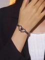 Elegant double heart bracelet with black zircons on model's wrist with black blazer - Black Double Heart Style