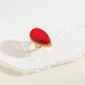Detail of gold ring featuring a large red teardrop gem surrounded by pavé diamonds - Ruby Teardrop