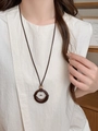 Vue détaillée du pendentif anneau en bois vintage et perle sur un collier long ajustable - Style Anneau Rond Marron