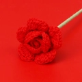 Macro view of handmade red crochet rose with detailed knit texture and green stem - Red