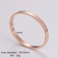 Detail view of rose gold stainless steel bangle with engraved Roman numerals - Women's Rose Gold