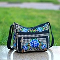 Detailed close-up of ethnic floral embroidery on black canvas crossbody bag outdoors - Lotus Flower Blue