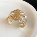 Detailansicht der gehämmerten Textur eines goldenen offenen Armreifs auf einem weißen Teller - Gehämmerter Stil (9#) / Gold