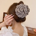 Detail view of a large grey fabric camellia flower hair claw clip on a woman's hair - Khaki Camellia (Small Claw)