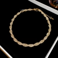 Detailed view of golden mesh twist necklace displayed in a premium black velvet jewelry box - Entwined / Gold / Necklace