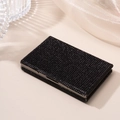 Macro detail of black rhinestone card holder with metallic frame on silk backdrop - Black