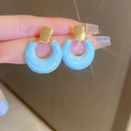 Blue enamel hoop earring with golden rectangular stud held by fingers, elegant design - Blue Drip Circle