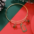 Close-up of golden adjustable Christmas bracelet with red and green charms and festive tag - Festive Tag (D1360)