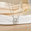 Detailed close-up of crescent moon and sun pendant necklace with zircon stones - Silver Hollow Sun Moon Wing Necklace XL0480G