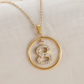 Macro shot of gold necklace with round pendant featuring a zircon-encrusted number 8 - Gold Number 8