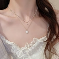 Detailed view of a layered necklace featuring white pearls and a gold heart pendant - 28# Necklace-Gold
