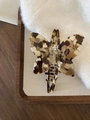 Vlindervormige haarklem van acetaat met schildpadpatroon en gouden gravering - Koffie Met Melk Textuur
