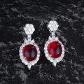 Detail of silver drop earrings featuring oval ruby stones and floral zircon accents - Red Zirconia Stud Earrings