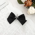 Dettaglio ravvicinato di un fiocco in raso nero gotico con ciondolo a croce argento antico - 3# Satin Nero Opaco con Croce Traforata Vintage