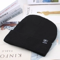 Detailed knit texture of a black winter beanie featuring a stylish woven patch label - Black (TF Label)