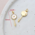 Macro detail of 14k gold-filled key pendant with white shell and measurements 11x33mm - 15# Key Heart Mother of Pearl