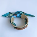 Dettaglio del bracciale rigido oro opaco con foulard in seta blu e bordi con trama seghettata - B26 Blu Largo