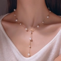 Y-shaped gold pearl necklace with diamond cat eye opal cross pendant on model - 11# Necklace—Gypsophila Sized Pearls