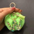 Detail of green faux fur pompom keychain with a resin letter W and sequined heart - Letter W