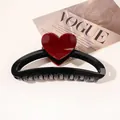 Detail of a large black shark hair claw clip with a glossy red heart on fashion magazine - Heart Hollow Semicircle / Black