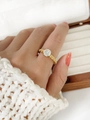 Close-up of golden twisted rope ring with a sparkling round zircon on a model's hand - US 7 / Round