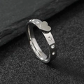 Polierter Edelstahlring mit Herz-Motiv und glitzernden Kristallen auf Stein-Hintergrund - US 6 / Stahlfarbe