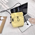 Dettaglio di una piccola borsa a tracolla in nylon giallo con coulisse e tracolla nera - Giallo