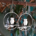 Silver owl earrings with leaf and branch design hanging on a natural tree branch - Owl Silhouette (2) / Silver