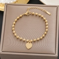 Dettaglio del bracciale a sfere dorate con pendente a cuore inciso LOVE FOREVER 520 - Oro