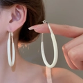 Gros plan de boucles d'oreilles ovales crème et argent portées par un mannequin - Blanc Cassé-Boucles d'Oreilles Ovales Épissées