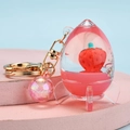 Porte-clés à sable mouvant rose avec pendentif fraise flottante en forme de fusée - Forme de fusée avec perle décorative