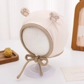 Detail der rosa Babyhaube aus Baumwolle mit Ohrenklappen, Stickerei und Bindeband - 46-48cm (5-15 Monate) / Gebrochenes Weiß