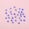 Irregular blue flower-shaped glass beads for DIY jewelry making on pink background - Blue