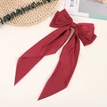 Detailed view of a vintage dark red silk satin bow hair clip with elegant long ribbons - Red