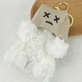 Close-up of white plush Westie keychain wearing a brown canvas hat with X_X embroidery - White Dog - Speechless
