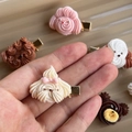 Detailed view of handmade puppy cookie hair clips in various colors with metal base - Maltese