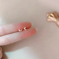 Minimalist 925 silver crescent moon stud earrings held to show tiny delicate scale - Moon / Silver
