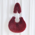 Detail of burgundy plush crescent bag featuring premium faux fur and silver metal chain - Burgundy