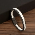Détail du bracelet en cuir tressé noir et blanc avec fermoir magnétique noir sur bois - Blanc