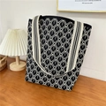 Close-up of black and white geometric diamond knit tote bag on a wooden table - 12 Rain Line Grid Black