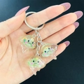 Detailopname van doorschijnende hars kwallen sleutelhangers met glitters en goudfolie - Groen