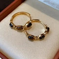 Close-up of golden hoop earrings with brown tiger eye stones in a jewelry box - 41# Gold Oval Tiger Eye Hoop Earrings