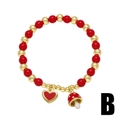 Pulsera de cuentas rojas y doradas con dijes de corazón y hongo sobre un fondo blanco puro - Colgante Corazón Champiñón (B)