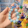 Laccetto portacellulare blu con perline, ciondolo a forma di orso e fiocco iridescente - Celeste