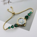 Detail of gold bracelet watch with green heart gemstones and mother-of-pearl dial - Gold Green